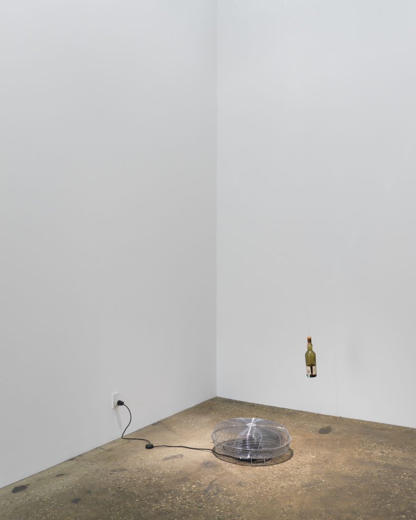 Gallery with fan on floor and suspended bottle