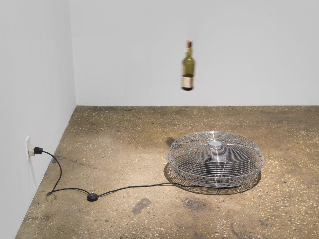 Gallery with fan on floor and suspended bottle
