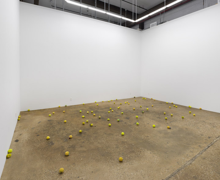 Large gallery space with tennis balls on floor