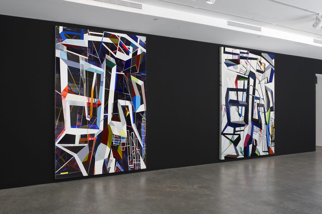 Geometric paintings in gallery on black wall