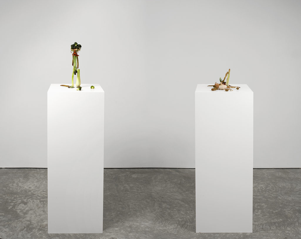 two small sculptures on pedestals